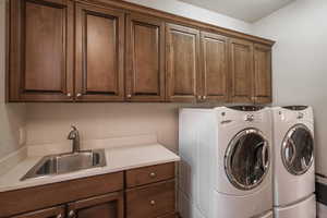 Laundry area featuring separate washer and dryer and cabinet space