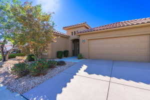 Mediterranean / spanish home featuring driveway, stucco siding, a tile roof, and an attached garage