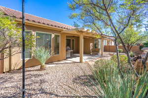 Back of property with a patio, stucco siding, a fenced backyard, and a tiled roof
