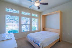 Bedroom with carpet floors, a wal bed, and a ceiling fan