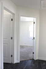 Hallway featuring dark wood-type flooring and baseboards