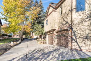 View of home's exterior featuring stucco siding, concrete driveway, and an attached garage