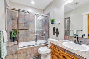 Full bathroom featuring vanity, tiled shower / bath combo, and recessed lighting