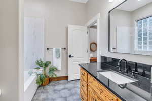 Full bath with vanity and baseboards