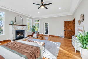 Bedroom featuring light wood-style floors, a premium fireplace, access to exterior, recessed lighting, and a ceiling fan