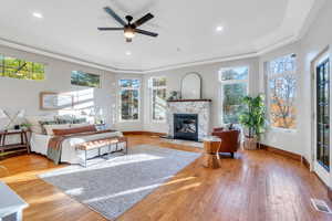 Bedroom featuring light wood-style flooring, access to exterior, recessed lighting, a fireplace, and crown molding