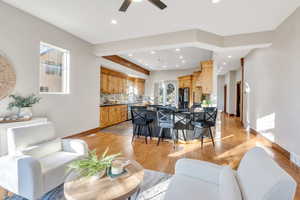 Living room featuring light wood-type flooring, arched walkways, a ceiling fan, and recessed lighting