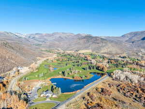 Aerial view of property's location featuring a water and mountain view and a golf club