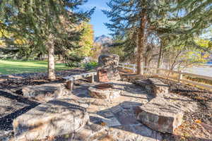 View of patio with a fire pit, a mountain view, and view of wooded area