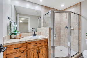 Bathroom featuring vanity, a stall shower, recessed lighting, and ceiling fan