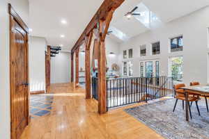 Hallway with hardwood / wood-style flooring, healthy amount of natural light, a high ceiling, and recessed lighting