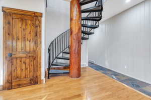 Stairs with hardwood / wood-style floors and wood walls