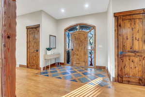Foyer entrance featuring inlaid floor details, wood-type flooring, and recessed lighting