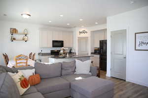 Living room featuring dark wood-type flooring and recessed lighting