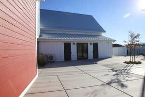 Rear view of house with a metal roof, french doors, and board and batten siding