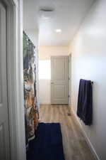 Full bathroom with light wood finished floors and curtained shower