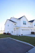 Modern farmhouse style home with board and batten siding, a front yard, a garage, and concrete driveway