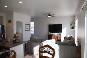 Living room featuring wood finished floors, ceiling fan, and recessed lighting