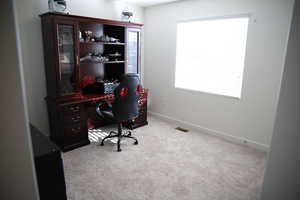 Carpeted home office featuring baseboards