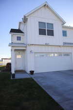 View of front of house with board and batten siding, a garage, and concrete driveway