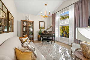 Living area featuring a chandelier, wood finished floors, and vaulted ceiling