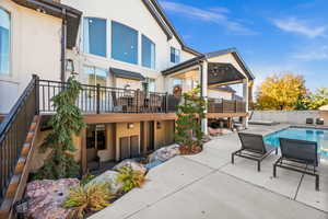 Rear view of property featuring stucco siding and a patio area