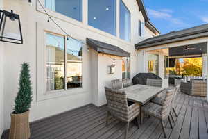 Wooden terrace featuring outdoor dining space, an outdoor hangout area, and a ceiling fan