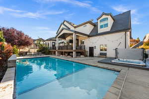 View of swimming pool featuring a patio area, a balcony, an outdoor hot tub, stairway, and a ceiling fan