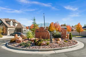View of front facade with stone siding, a mountain view, concrete driveway, and a garage