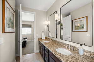 Bathroom featuring double vanity, light tile patterned flooring, and light carpet