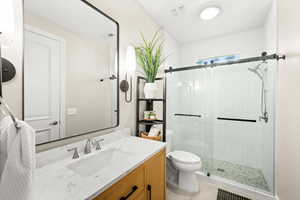 Full bath featuring vanity, a shower stall, and light tile patterned flooring