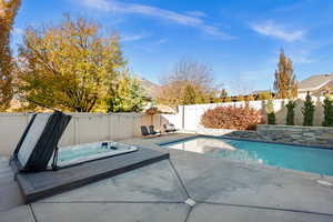View of swimming pool featuring a fenced backyard, a patio, and an outdoor hot tub