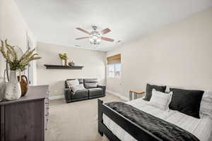 Bedroom featuring light carpet, a ceiling fan, and a textured ceiling