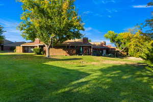 Back of property featuring a yard and a chimney