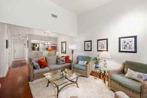 Living area featuring hardwood / wood-style floors, a high ceiling, and a chandelier