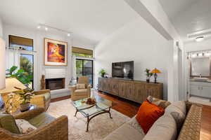 Living room featuring wood finished floors and a brick fireplace