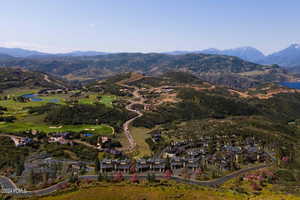 Aerial view of property and surrounding area featuring a water and mountain view and nearby suburban area