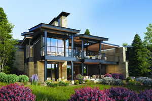 Rear view of house with a patio, stone siding, a chimney, and a balcony