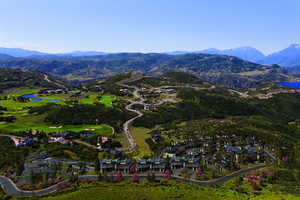 Aerial overview of property's location featuring a water and mountain view and nearby suburban area