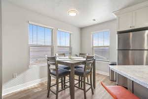 Dining room featuring light wood-style flooring and a textured ceiling