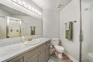 Bathroom featuring a stall shower, vanity, dark wood-type flooring, and a textured ceiling