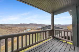 Wooden deck with a mountain view and a lawn