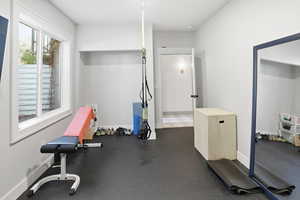 Exercise area with dark rubber floors and baseboards