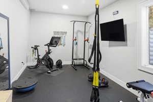 Exercise area featuring rubber floors, healthy amount of natural light, and recessed lighting