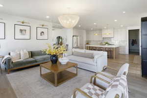 Living area with light wood finished floors, recessed lighting, and a chandelier