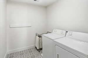 Laundry room with light tile patterned flooring and washer and dryer