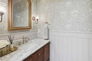 Bathroom featuring vanity and wallpapered walls
