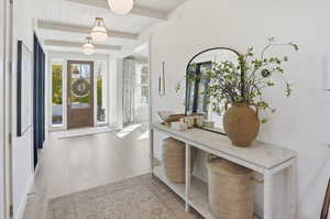 Foyer entrance with light wood-type flooring and a wood ceiling with exposed beams