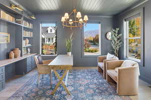 Office area featuring light wood-style flooring, a chandelier, and wooden ceiling