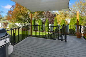 Wooden deck featuring grilling area, a yard, and stairway